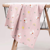 Lady Goose muslin swaddle draped over wooden crib